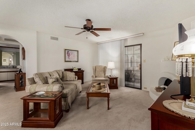 10410 N Cave Creek Rd Unit 2030, Phoenix, AZ 85020 - living area featuring light colored carpet, arched walkways, ceiling fan, and a textured ceiling