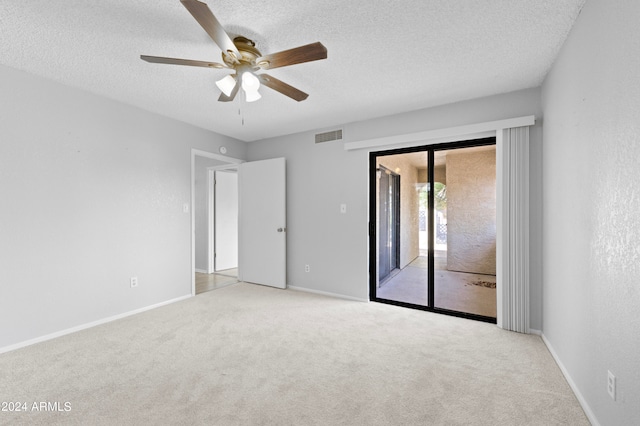 carpeted empty room with ceiling fan and a textured ceiling