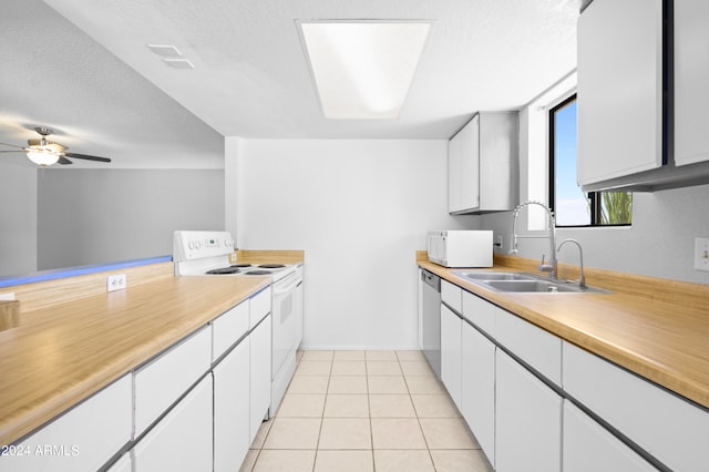 kitchen with white appliances, light tile patterned flooring, sink, ceiling fan, and white cabinets