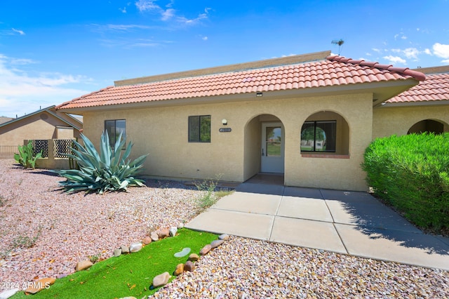 view of front of home with stucco siding and a tile roof