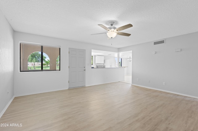 unfurnished living room featuring a textured ceiling, ceiling fan, and light hardwood / wood-style floors