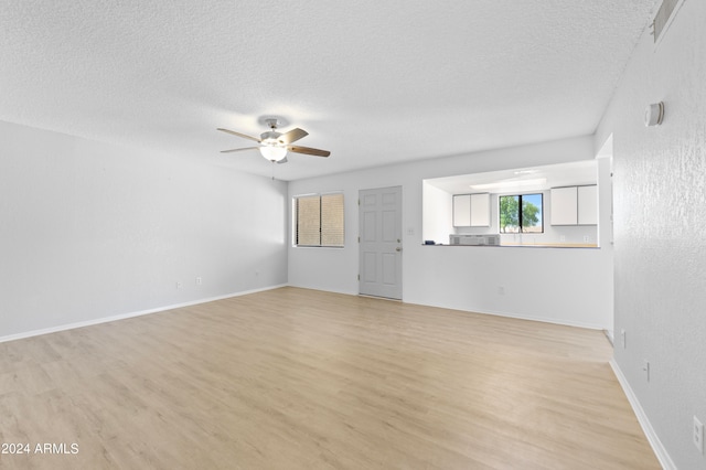 unfurnished living room featuring a textured ceiling, ceiling fan, and hardwood / wood-style flooring