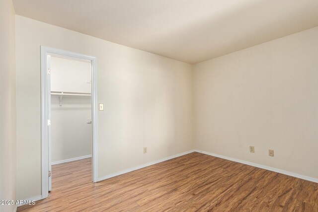 2164 S Estrella Cir, Mesa, AZ 85202 - unfurnished bedroom featuring light wood-type flooring, a walk in closet, and a closet