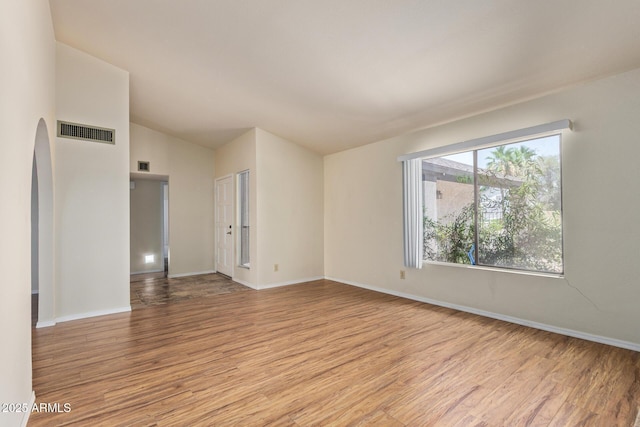 2164 S Estrella Cir, Mesa, AZ 85202 - unfurnished room with light wood-type flooring, vaulted ceiling, and arched walkways