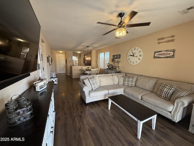 living area featuring dark wood-style floors, visible vents, and ceiling fan