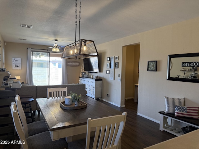 dining room featuring a textured ceiling, visible vents, baseboards, ceiling fan, and wood finished floors
