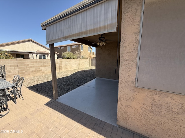 view of patio featuring fence, outdoor dining space, and ceiling fan