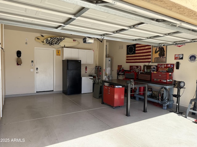 garage with gas water heater, a garage door opener, a workshop area, and freestanding refrigerator