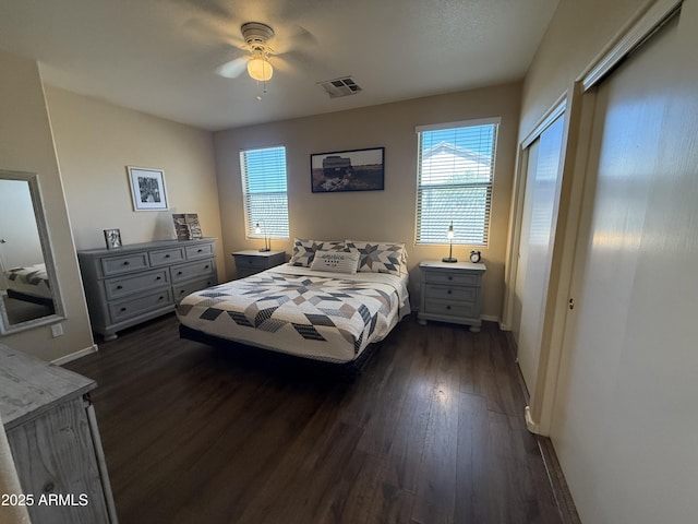 bedroom with multiple windows, visible vents, baseboards, and dark wood-style flooring