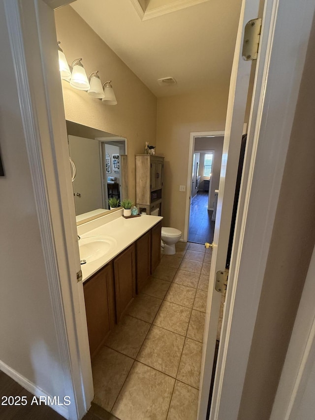 bathroom with toilet, vanity, tile patterned floors, and visible vents