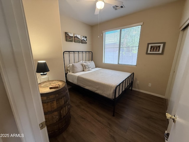 bedroom featuring a ceiling fan, visible vents, baseboards, and wood finished floors