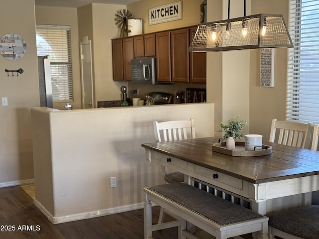 dining area with plenty of natural light, dark wood-type flooring, and baseboards