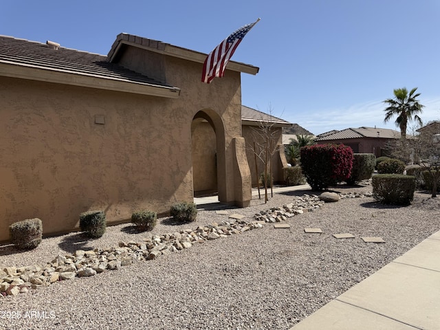 view of property exterior featuring a tile roof and stucco siding