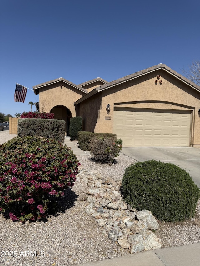 view of front facade featuring driveway, stucco siding, and an attached garage