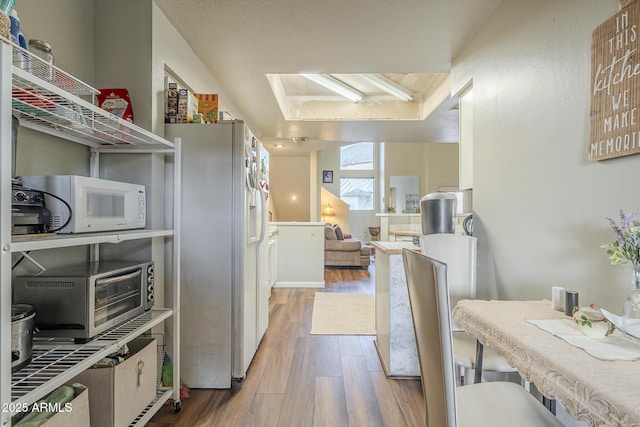 kitchen with hardwood / wood-style floors and white appliances