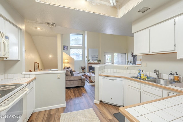 kitchen featuring tile countertops, white cabinetry, white appliances, and kitchen peninsula