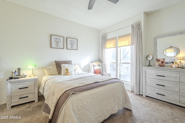 carpeted bedroom featuring ceiling fan and a textured ceiling