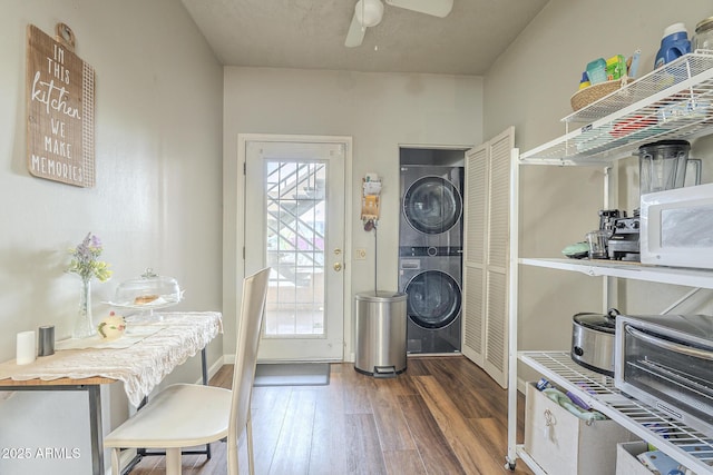 interior space with dark hardwood / wood-style floors, stacked washer / dryer, and ceiling fan