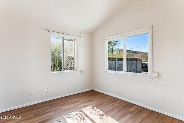 spare room with vaulted ceiling and wood-type flooring