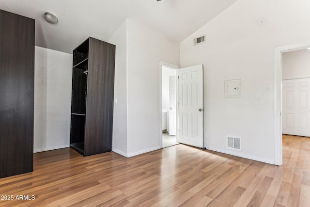 unfurnished bedroom featuring high vaulted ceiling and light wood-type flooring