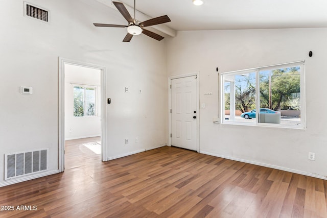 unfurnished room with hardwood / wood-style flooring, plenty of natural light, and beamed ceiling