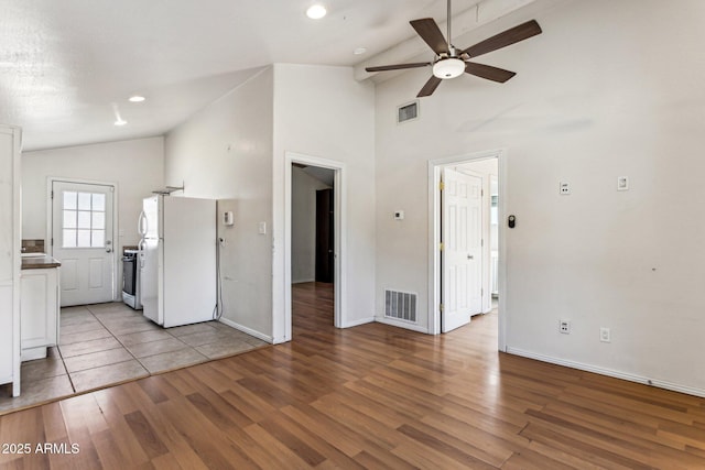 unfurnished living room featuring ceiling fan, light hardwood / wood-style flooring, and lofted ceiling