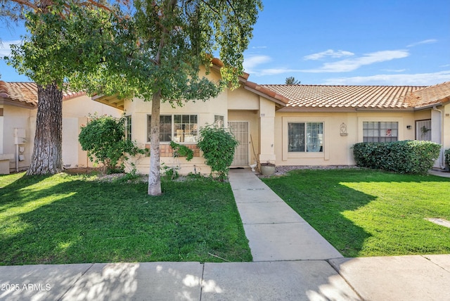 mediterranean / spanish-style home with a front lawn