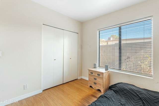 bedroom with a closet and light hardwood / wood-style flooring