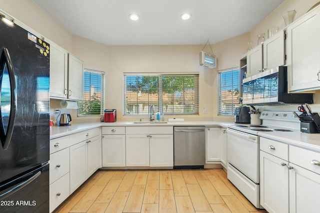 kitchen featuring sink, white cabinetry, stainless steel appliances, an AC wall unit, and light wood-type flooring