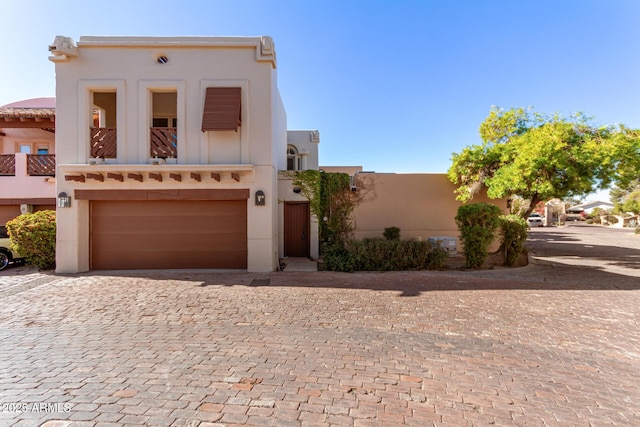 pueblo revival-style home with a garage