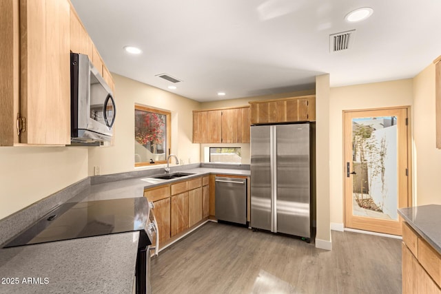 kitchen with sink, light brown cabinets, light hardwood / wood-style flooring, and appliances with stainless steel finishes