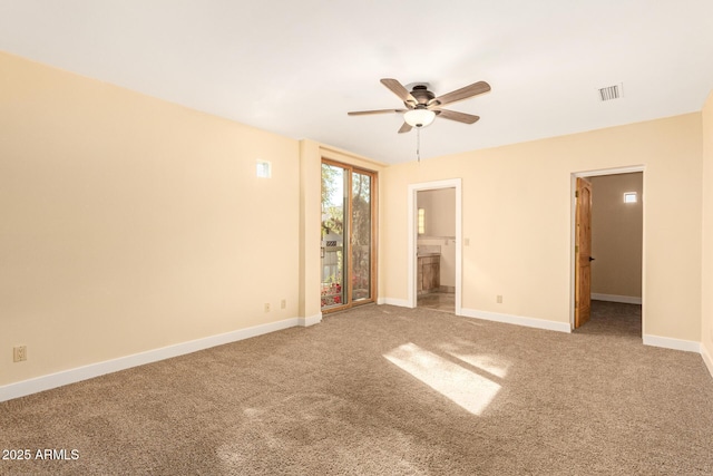 unfurnished bedroom featuring ceiling fan, ensuite bathroom, a spacious closet, and carpet