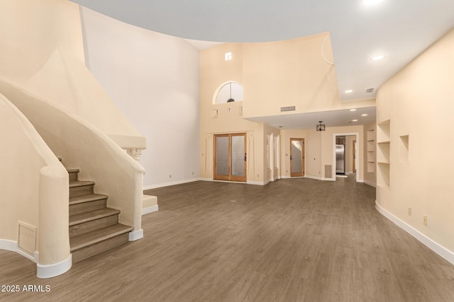 unfurnished living room with wood-type flooring and built in features