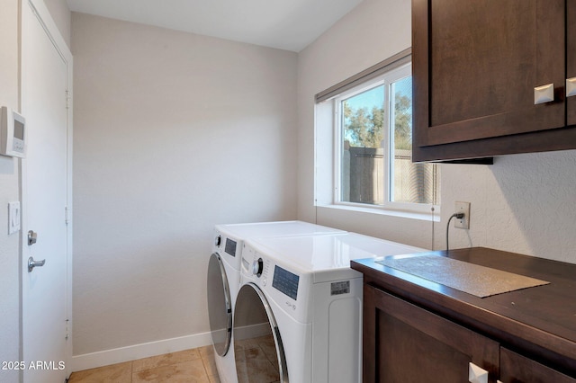 laundry room featuring light tile patterned floors, washing machine and dryer, and cabinets