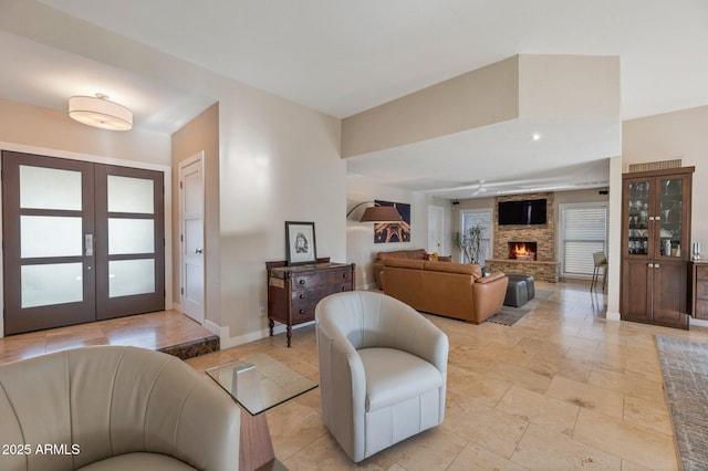 living room with french doors and a stone fireplace