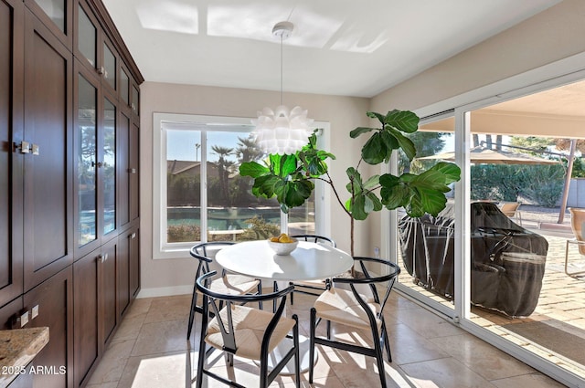 tiled dining room with an inviting chandelier