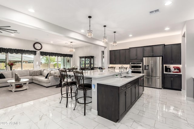 kitchen featuring open floor plan, appliances with stainless steel finishes, a sink, and visible vents