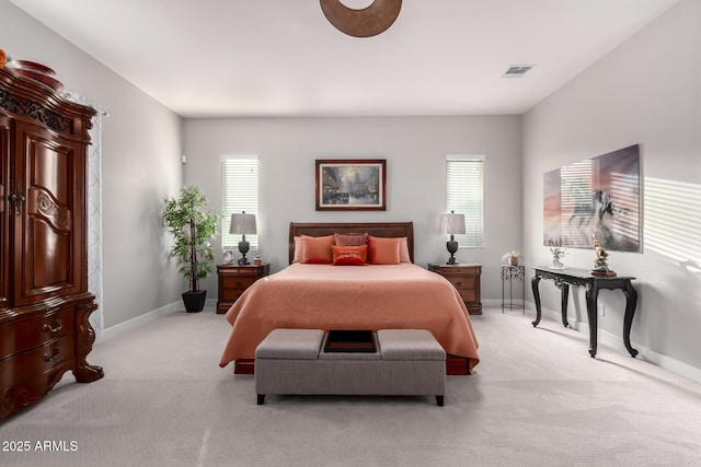 bedroom with light colored carpet, visible vents, and baseboards