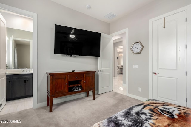 bedroom featuring light carpet, ensuite bath, visible vents, and baseboards