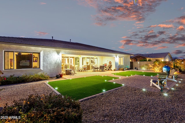 back of house featuring a patio area, fence, and stucco siding