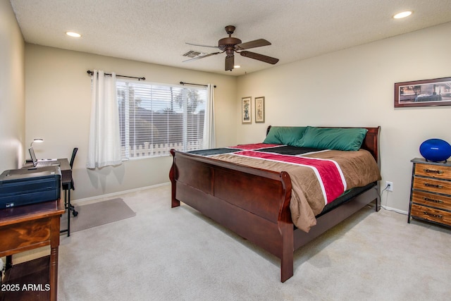 carpeted bedroom with ceiling fan and a textured ceiling