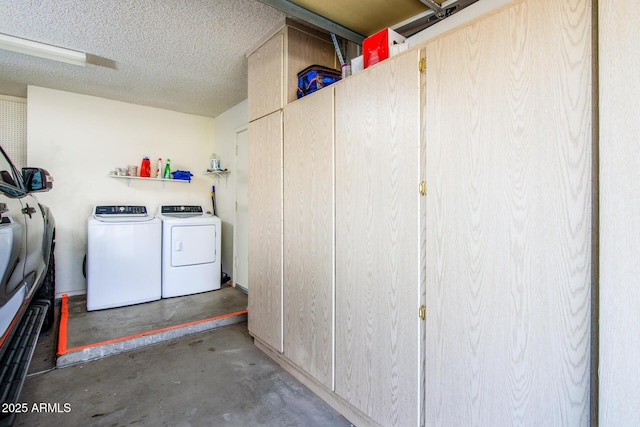 clothes washing area with independent washer and dryer and a textured ceiling