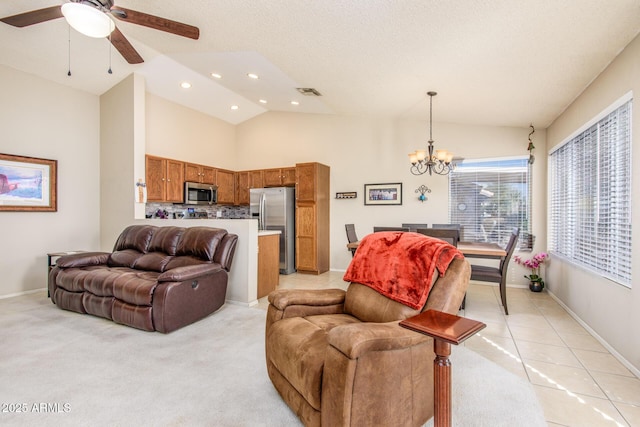 living room featuring ceiling fan with notable chandelier, high vaulted ceiling, and light tile patterned floors