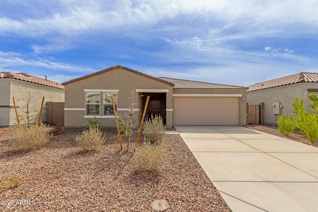 view of front of house featuring a garage, a tile roof, driveway, and stucco siding