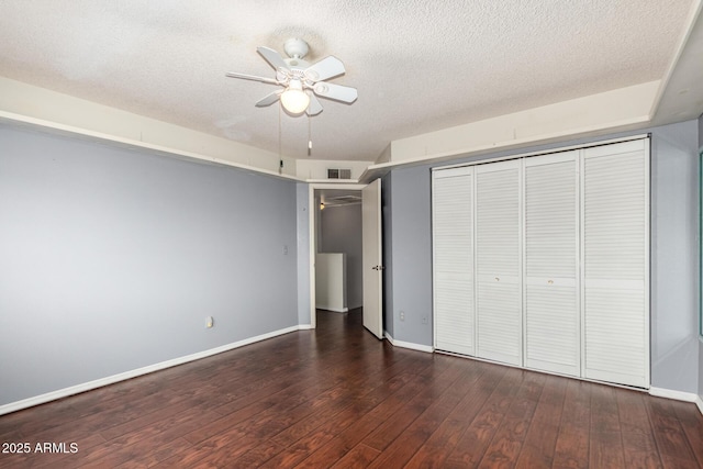 unfurnished bedroom with dark hardwood / wood-style flooring, ceiling fan, a closet, and a textured ceiling