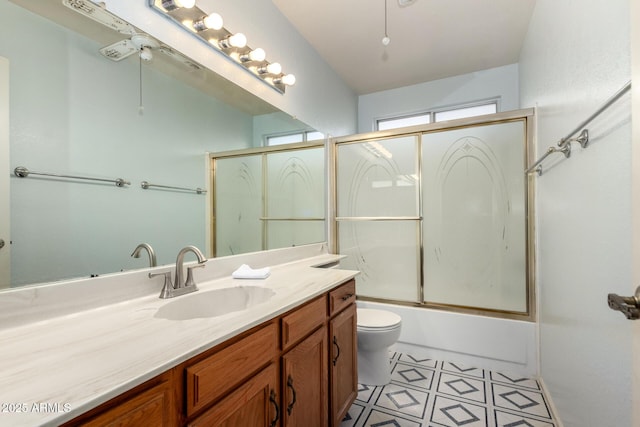 full bathroom with combined bath / shower with glass door, vanity, and toilet