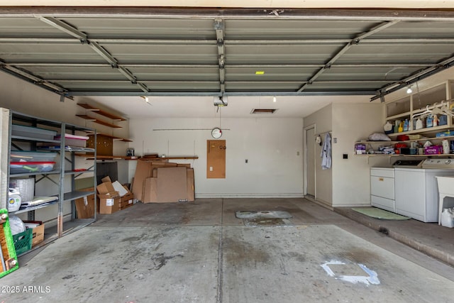 garage with independent washer and dryer and a garage door opener