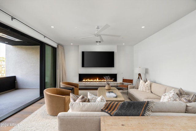 living room with ceiling fan and light hardwood / wood-style flooring