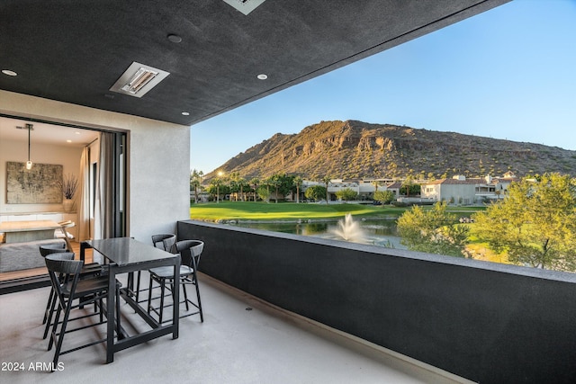 balcony featuring a water and mountain view