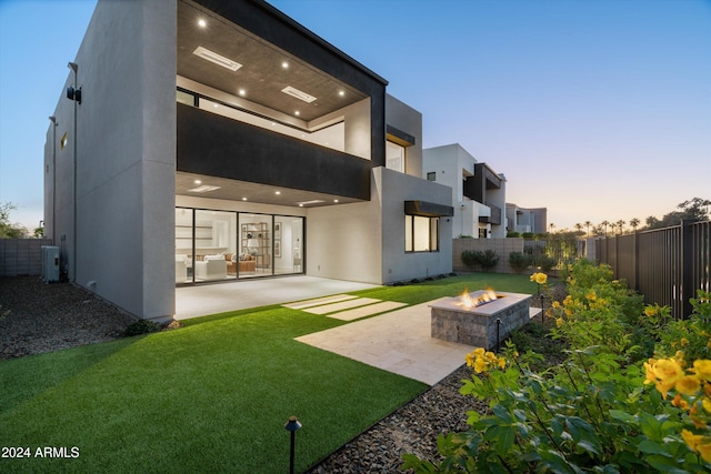 back house at dusk featuring a patio, a fire pit, and central AC unit